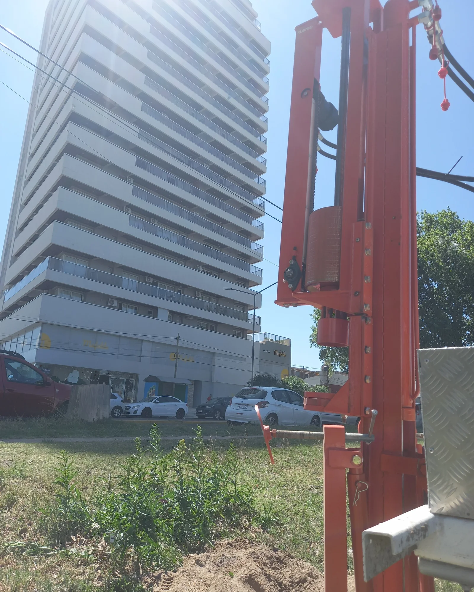 Equipo de perforación geotécnica junto a un edificio